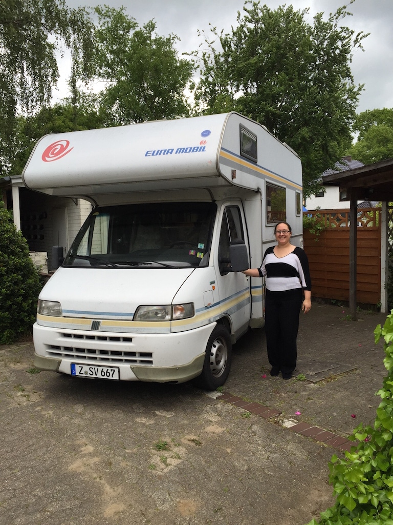 Ein Wohnmobil auf einem Hof mit einer Frau