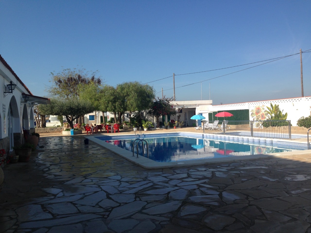 Ein Pool und im Hintergrund ein Spielplatz