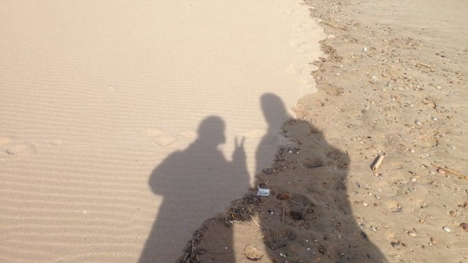 Zwei menschliche Schatten im Sand