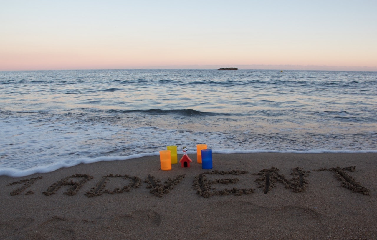 Im Hintergrund das Meer, im Vordergrund 4 Kerzen und in den Sand geschrieben "1. Advent"