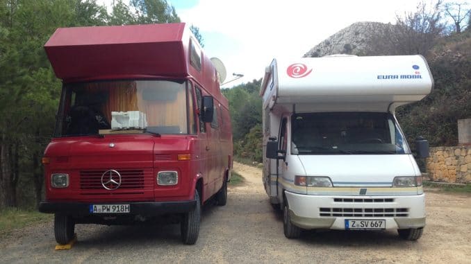 Ein roter Mercedesbus als Wohnmobil und daneben ein weißes EuraMobil