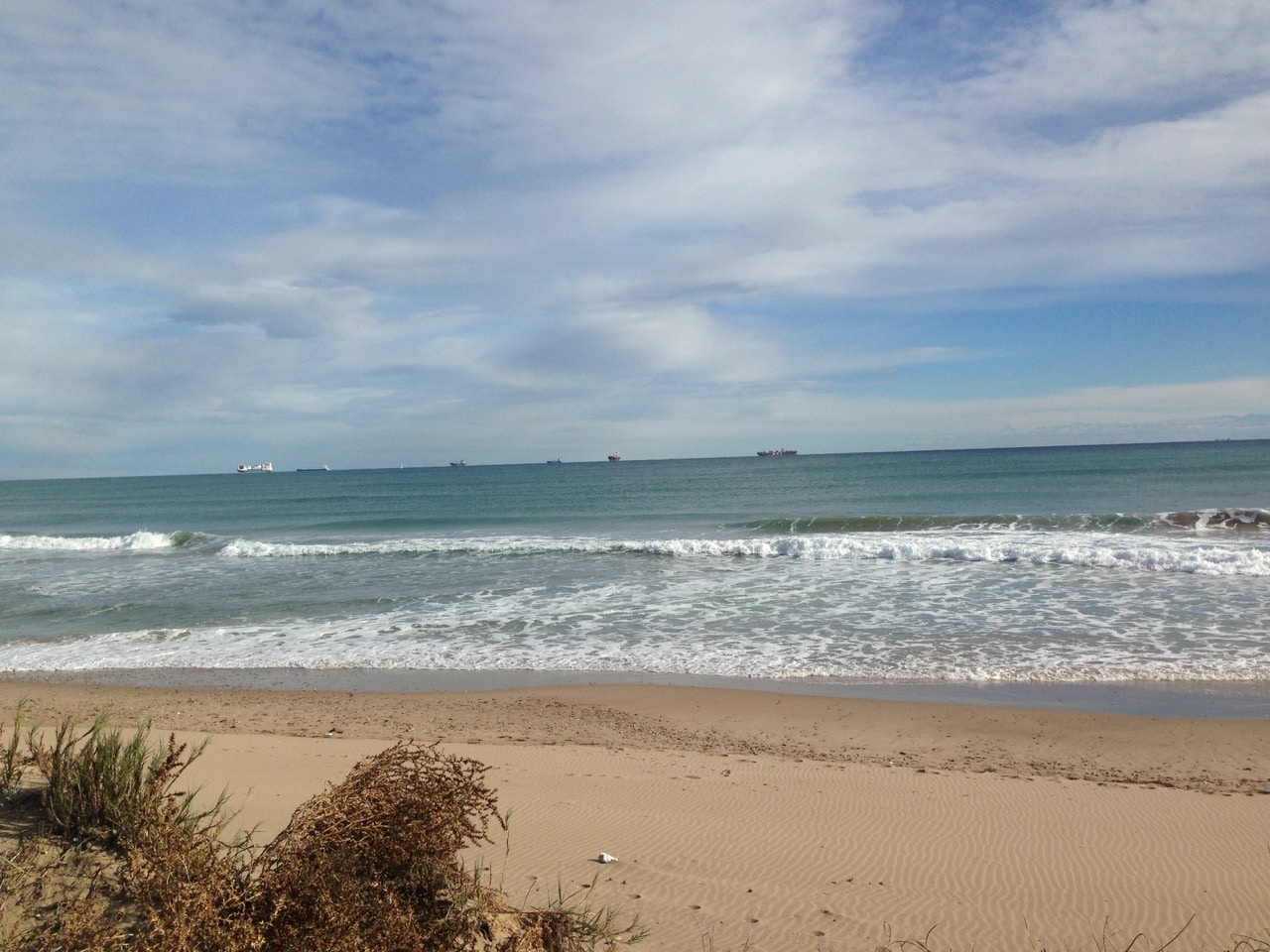 Ein Strand und Wellen unter einem wolkigen Himmel