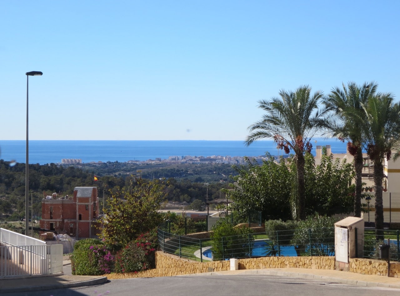 Blick an Häusern vorbei auf das entfernter liegende Meer