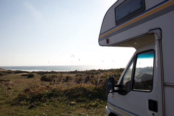 Ein Wohnmobil schaut auf's Meer im Hintergrund viele Kite