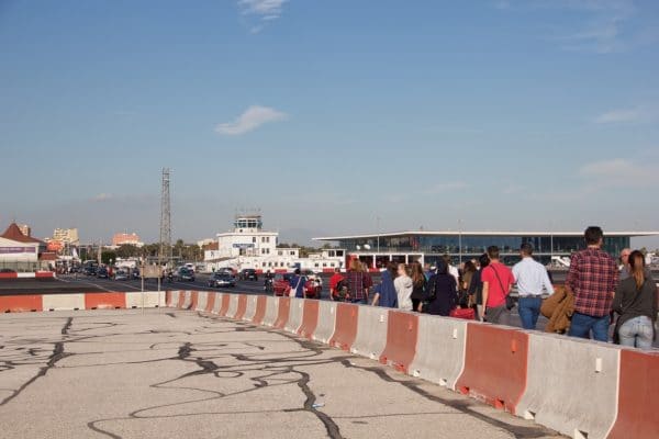 Viele Menschen und Autos überqueren das Flugfeld in Gibraltar