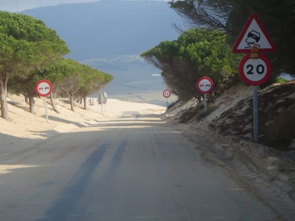 Straße mit Warnschildern und viel Sand