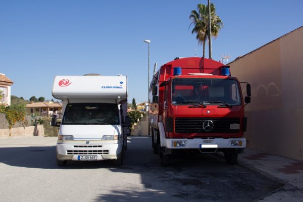 Ein Wohnmobil steht neben einem umgebauten Feuerwehrauto