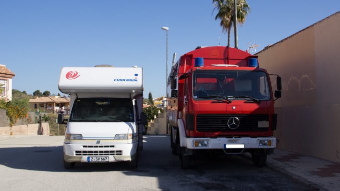 Ein Wohnmobil steht neben einem umgebauten Feuerwehrauto