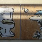 Zwei Holzschilder mit einer Toilette und einer Dusche