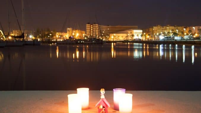 Vier Kerzen vor einem Hafen