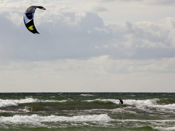 Ein Kitesurfer vor grauen Wolken