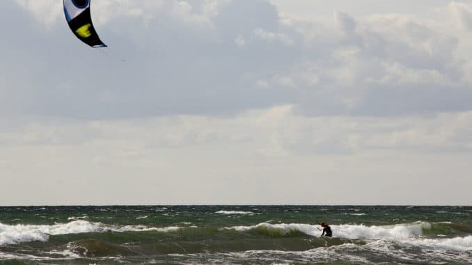 Ein Kitesurfer vor grauen Wolken