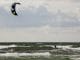 Ein Kitesurfer vor grauen Wolken