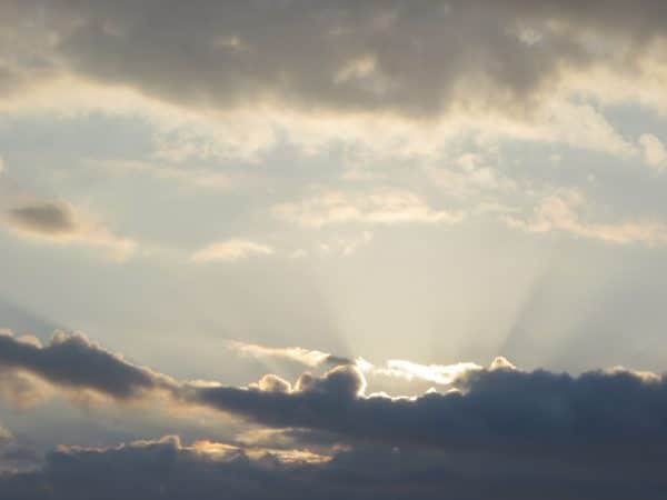 Sonne strahlt über eine dicke Wolke