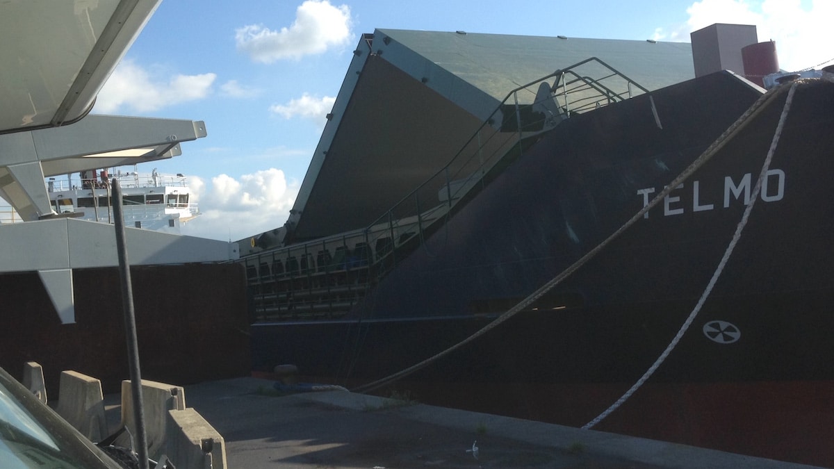 Ein Frachtschiff mit hochgeklappter Ladeluke im Hafen