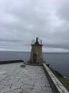 Ein kleiner alter Leuchtturm am Ende eines steinernen Weges