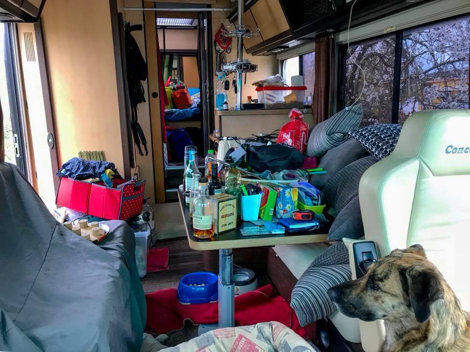 Blick von vorne ins Innere eines Wohnmobiles in dem haufenweise Kisten und Sachen stehen