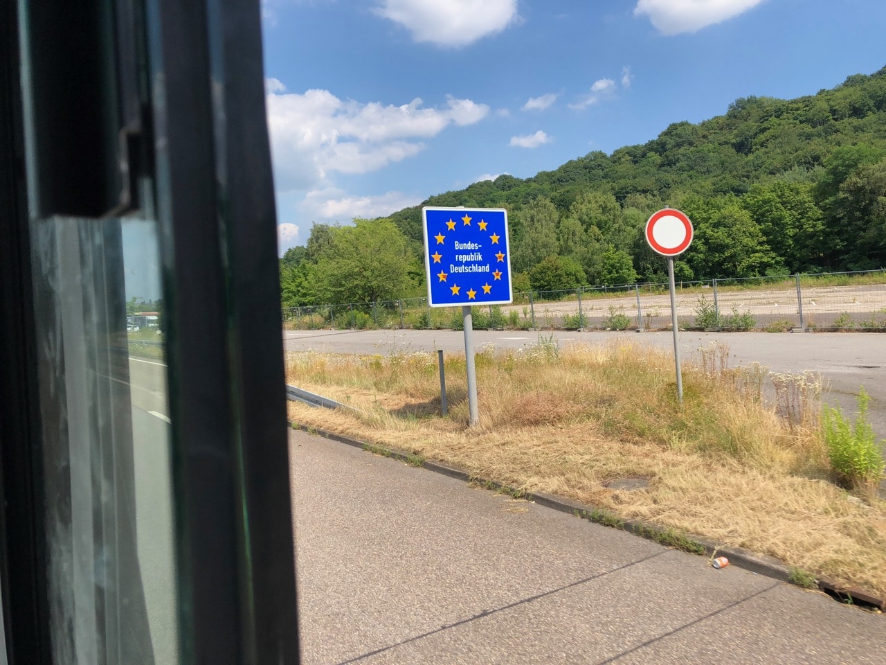 Aus dem Wohnmobilfenster heraus fotografiertes Grenzschild